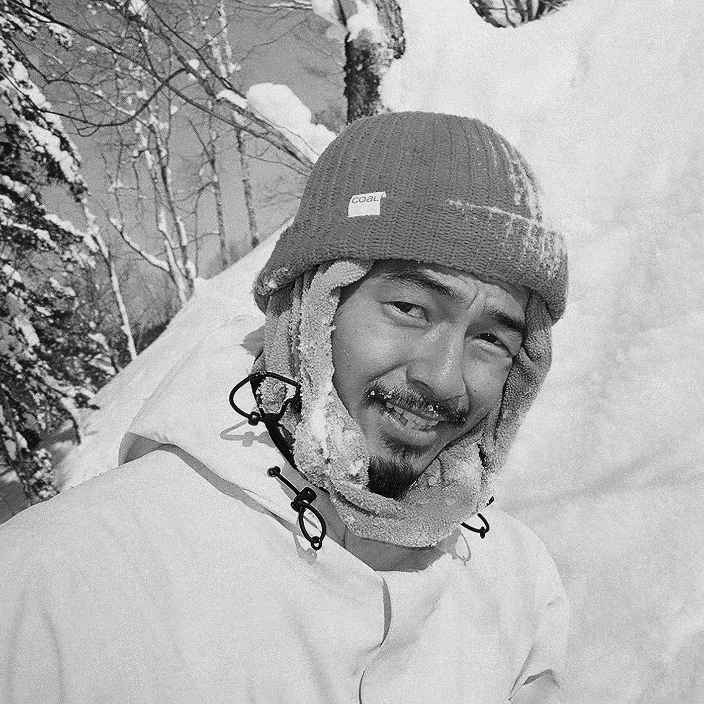 Black and white portrait of Kazu Kokubo smiling in the snow